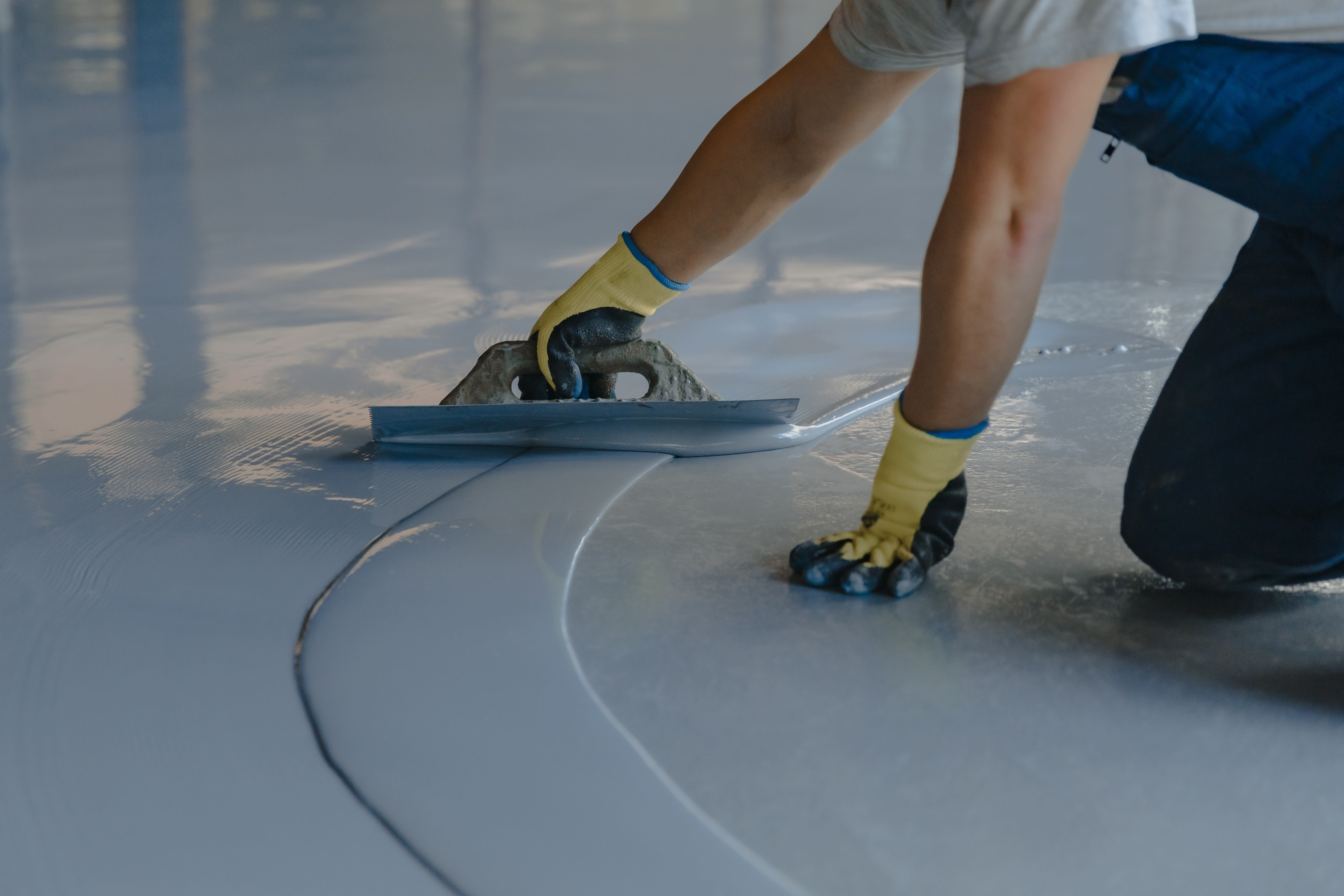 Technician applying floor coating system